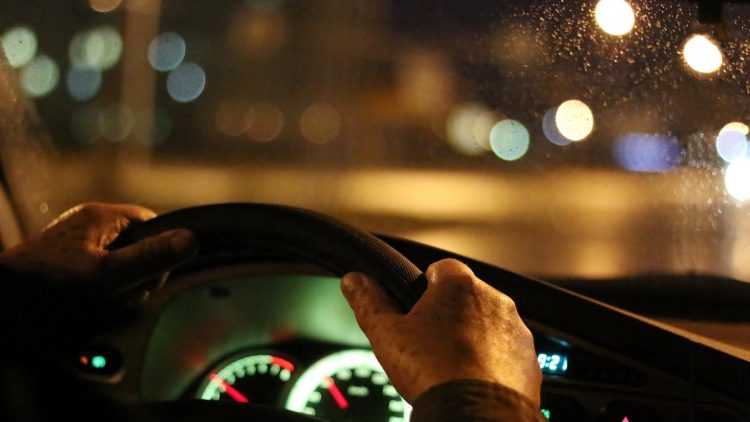 Ältere Person fährt nachts Auto