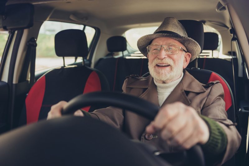 Zufriedener älterer Mann fährt Auto