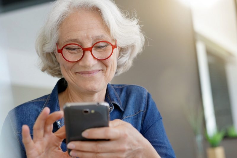 Ältere Frau nutzt Smartphone zur Unterhaltung