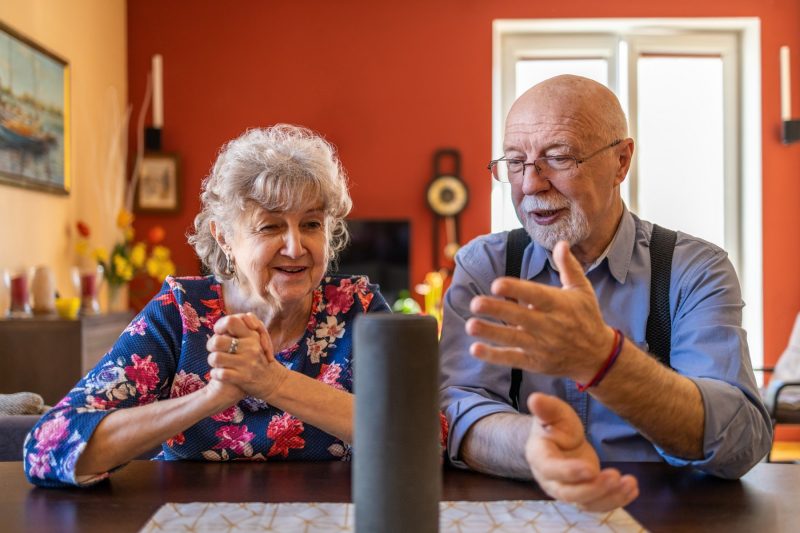  Älteres Ehepaar verwendet einen Sprachassistenten