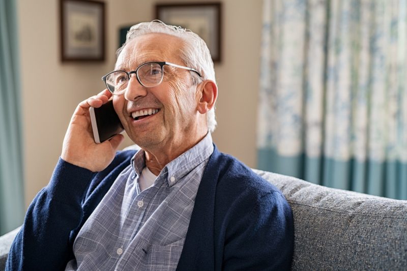Zufriedener älterer Mann telefoniert mit dem Smartphone