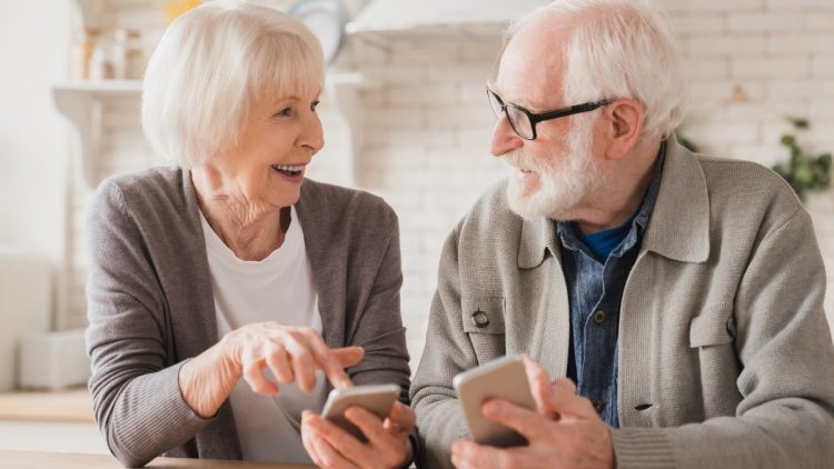 Zufriedenes älteres Ehepaar nutzt Smartphones