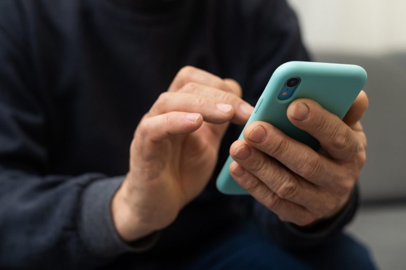 Ältere Person hält Smartphone in der Hand