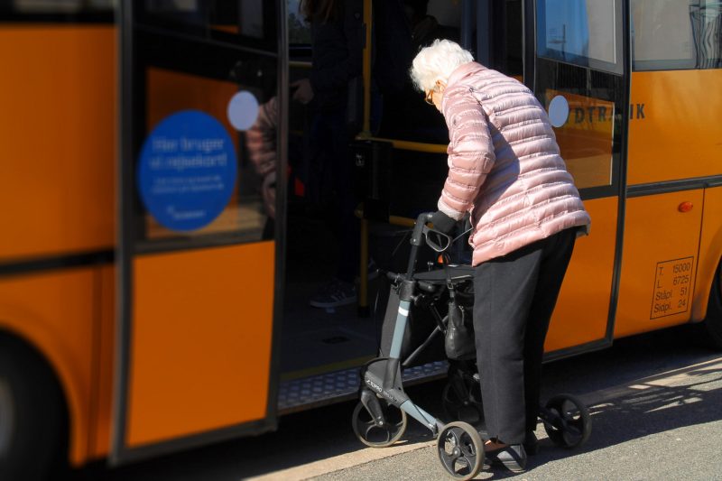 Seniorin mit Rollator steigt in einen Bus ein