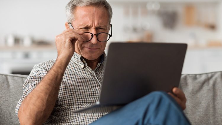 Älterer Mann nutzt Laptop