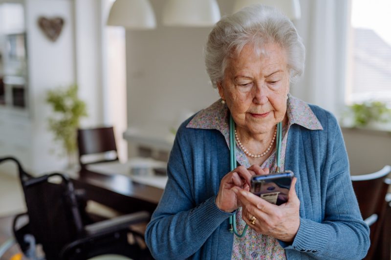 Seniorin bedient ein Smartphone
