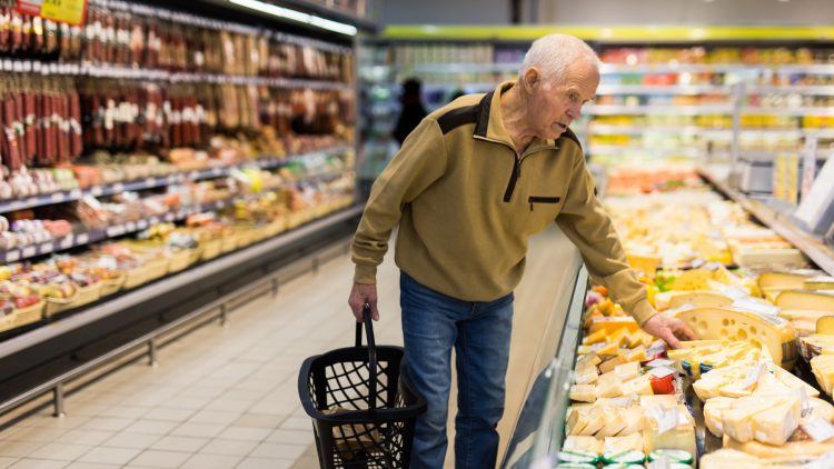Älterer Mann beim Einkaufen im Supermarkt