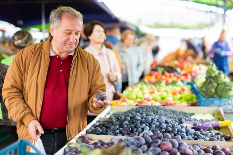 Älterer Mann kauft Obst auf dem Markt