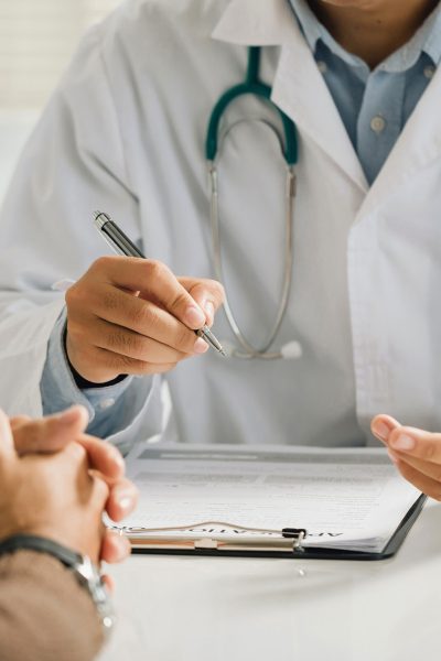 Arzt erläutert Patient Diagnose und Behandlung