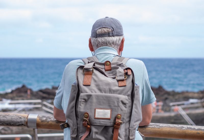 Älterer Mann mit Reiserucksack genießt den Ausblick