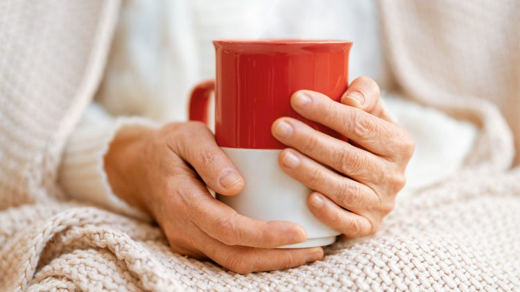 Die richtige Ernährung bei Erkältung oder Grippe - Hände an wärmender Tasse
