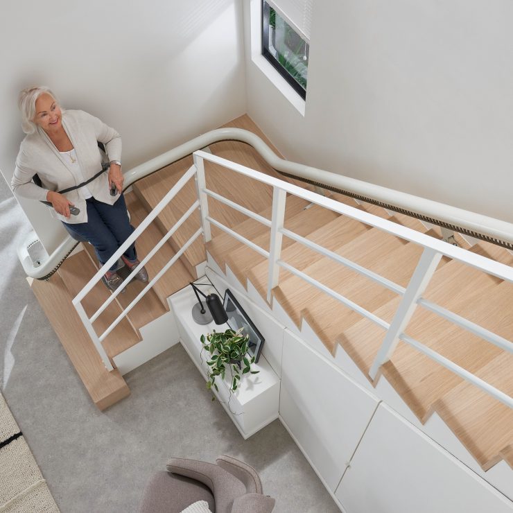 Frau schaut nach oben aus dem SANIMED 70 EXTRA Treppenlift für kurvige Treppen